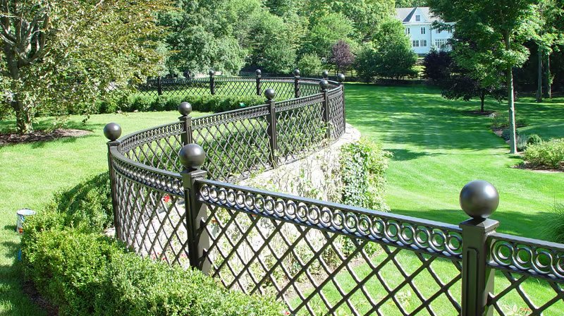 Winding metal fence on a stone barrier