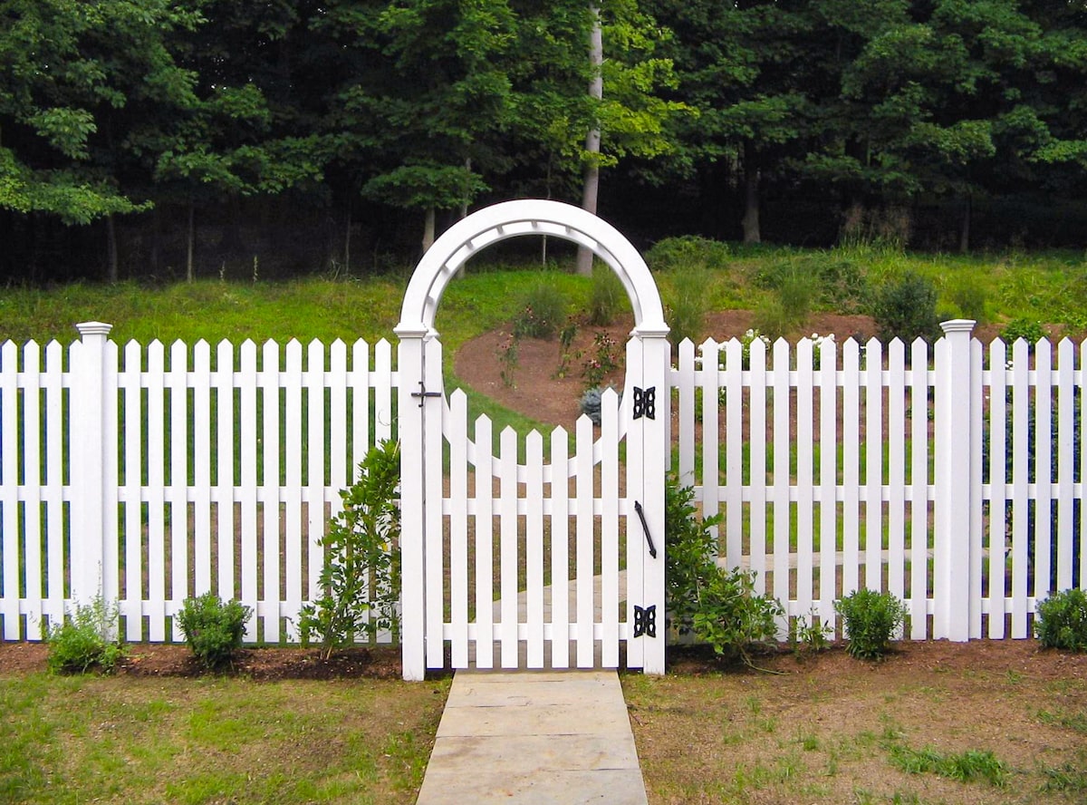 white wood picket fence with circular arbor