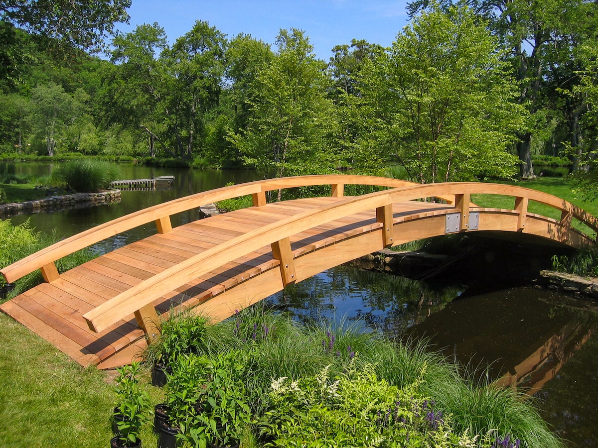 cedar curved bridge over the water front and side
