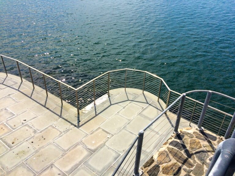 stone balcony with metal cable rail overlooking water