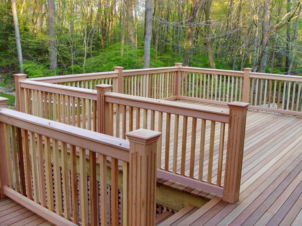 A natural wood deck is surrounded by a forest.
