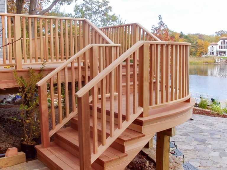 The custom wood staircase railings on this deck follow the curvature of the platform