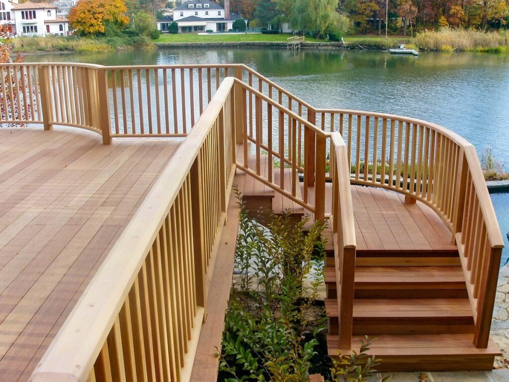 A wood deck overlooks a lake. 