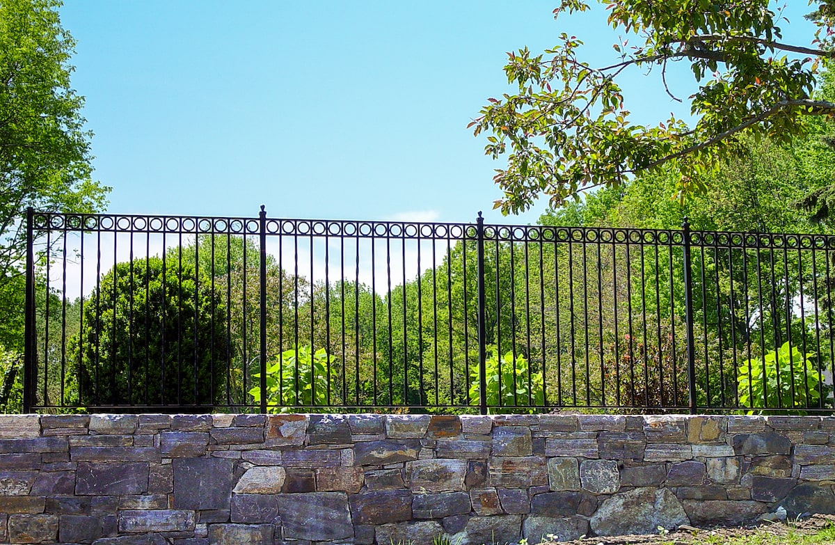 black metal deer fencing with stonework