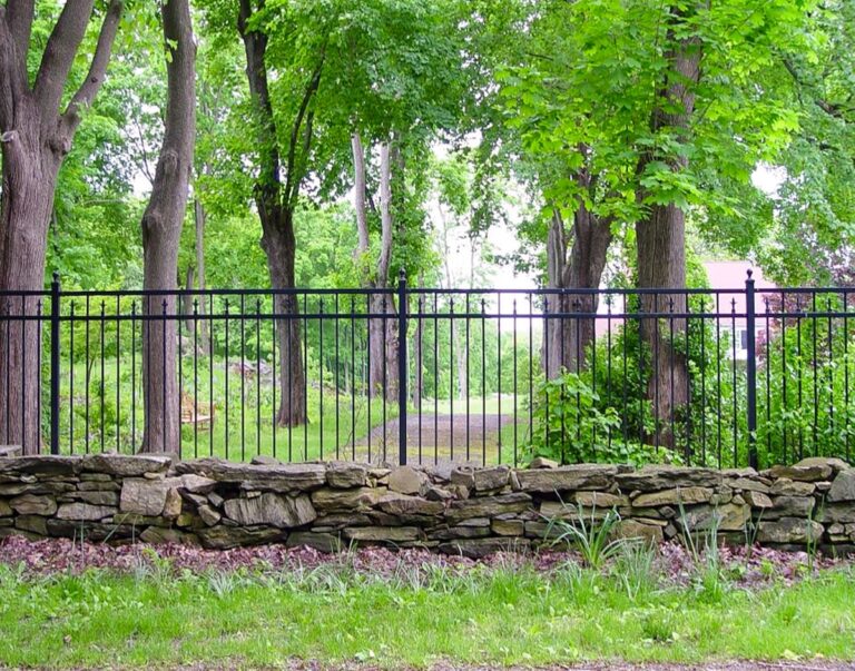 traditional wrought iron deer fence with stonework