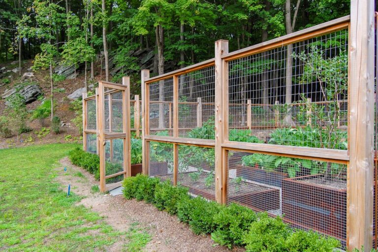 A tall fence is made of fully framed mesh panels.