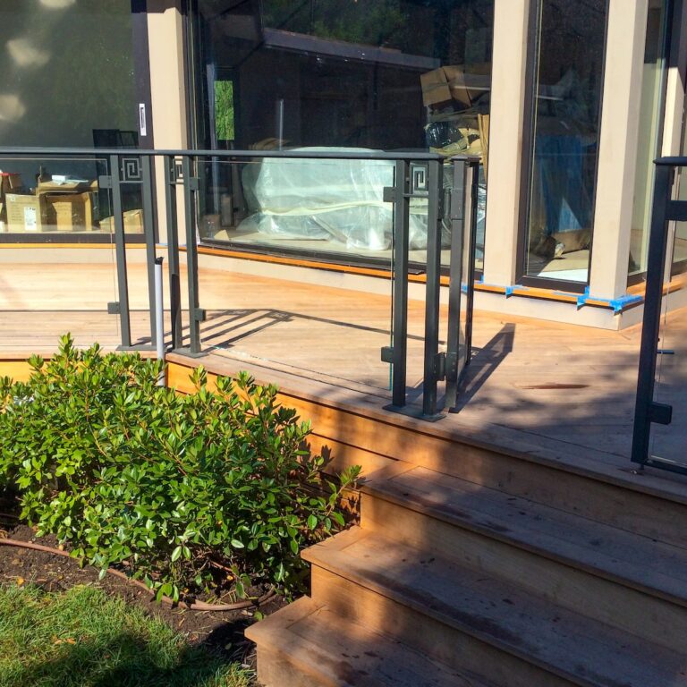 Note the intricate custom metal work between the panels of this glass railing.