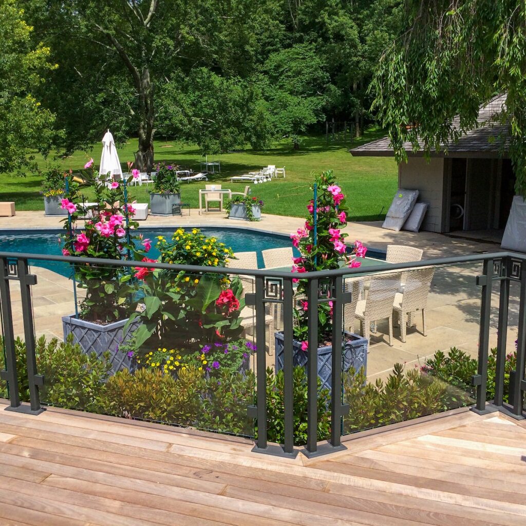 A glass railing surrounds a pool.