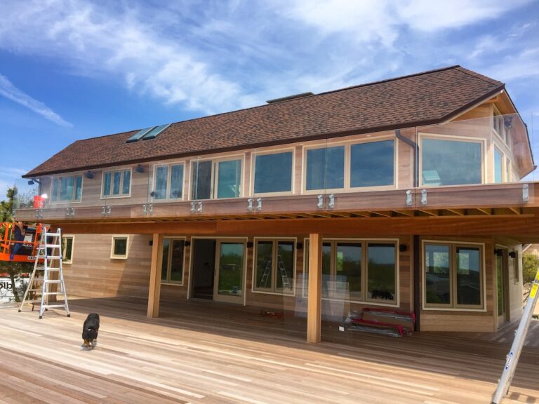 An unframed glass balcony protects this second floor balcony without affecting the view.