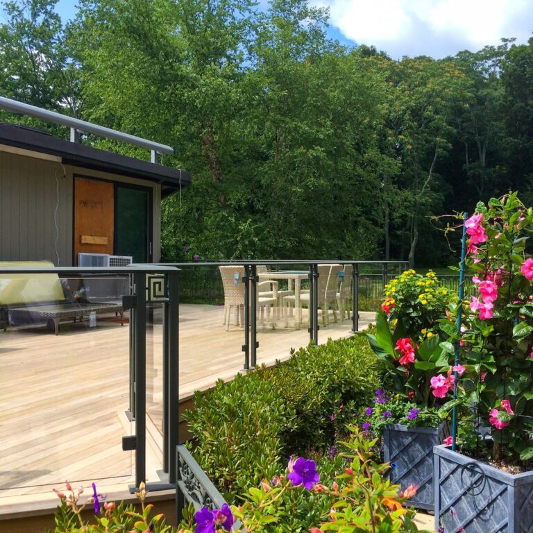 The landscaping around this glass railing helps define the space.