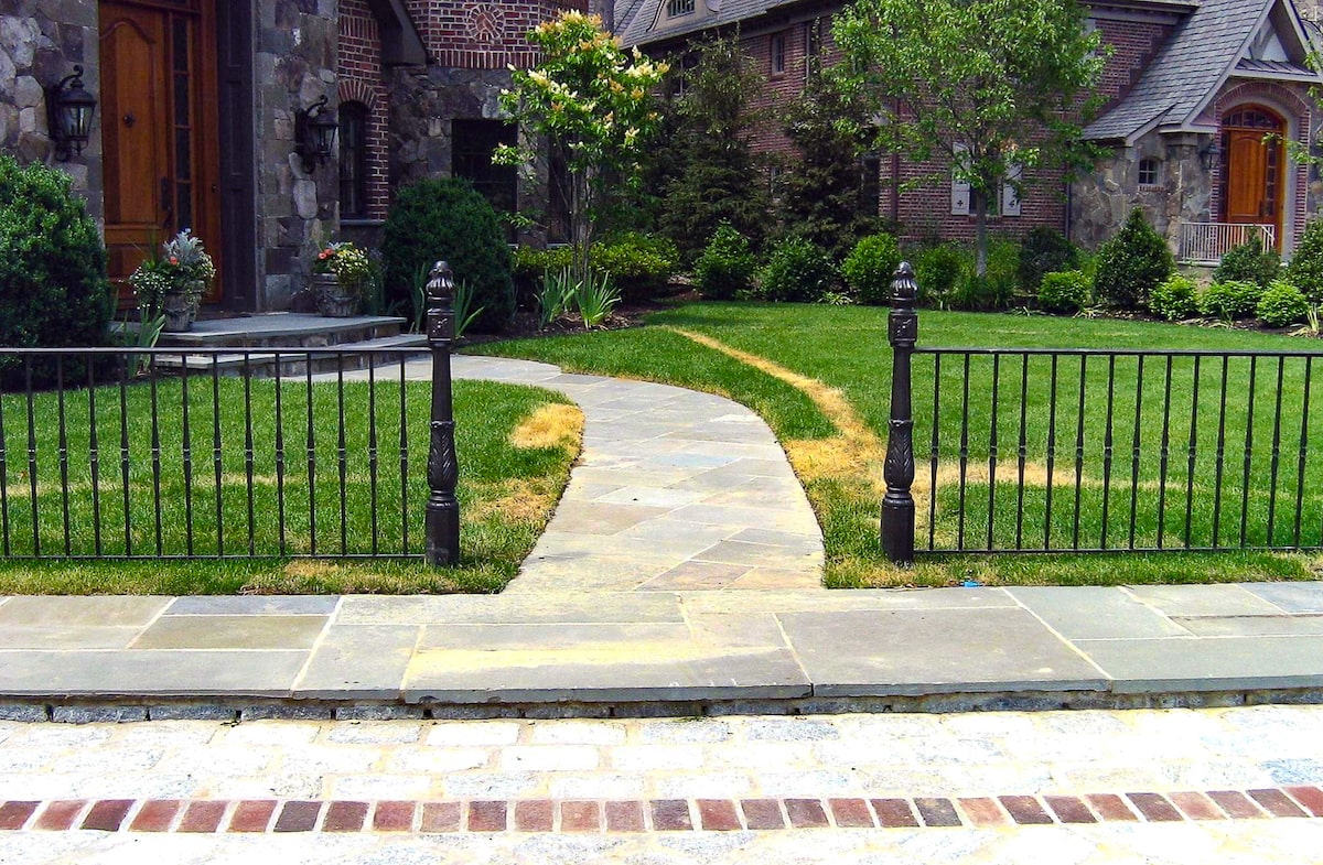 A short metal fence with two posts on either side of a walkway.