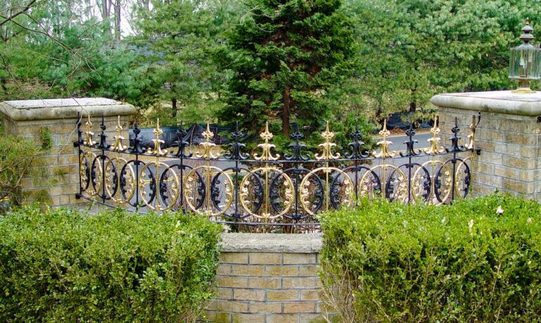 An intricately designed alternating bronze and wrought iron metal fence design.