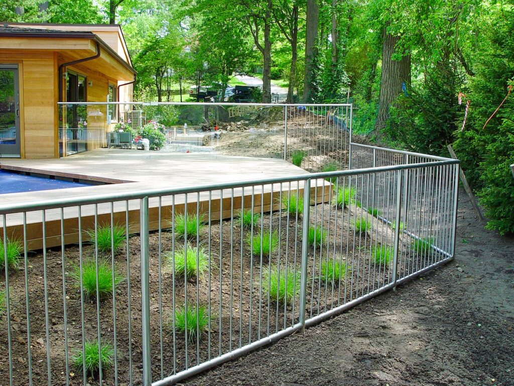 This pool gate is a mix of two types: a vertical cable-inspired stainless steel railing and a transparent glass railing.