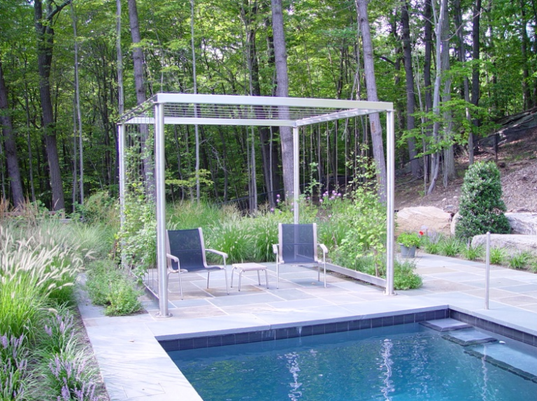 A metal pergola beside a swimming pool.