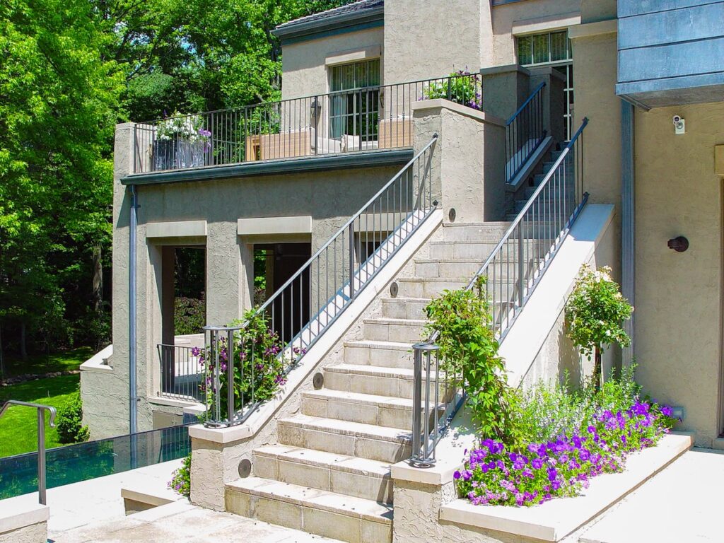 A metal railing wraps around an outdoor staircase and upper deck. 