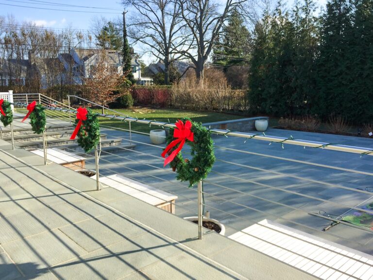 The cable railing on this deck is decorated with wreaths and Christmas lights.