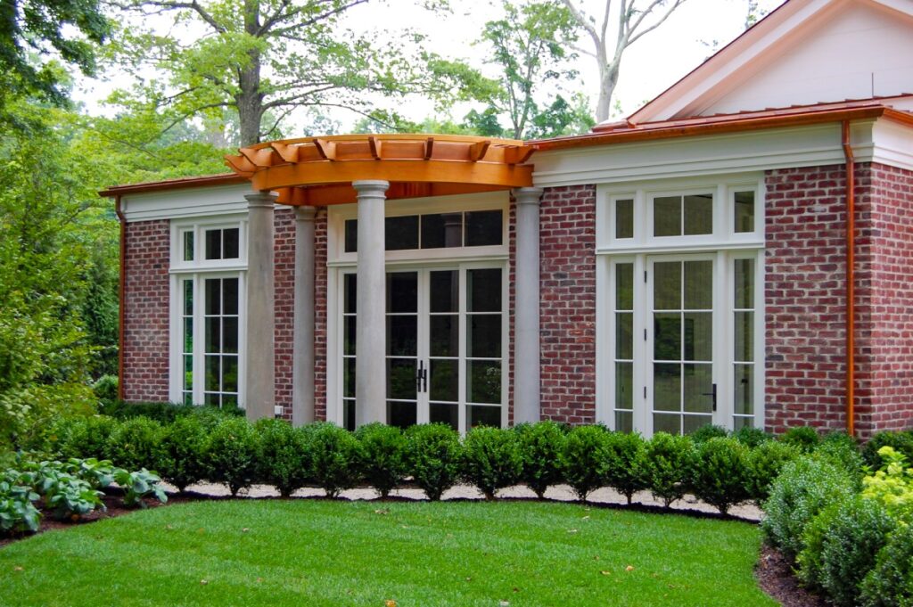 A small curved pergola covers a building’s entrance.