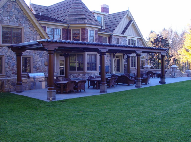 A wooden pergola roof covering a grilling area.