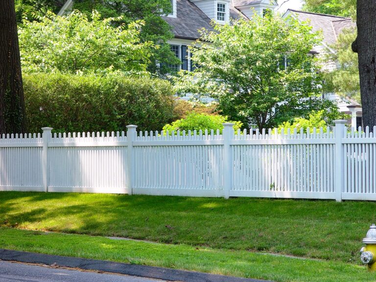 This white PVC fence has slats spaced closely together to provide privacy from the street for the front yard and home behind it.