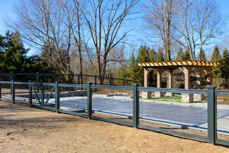 green mesh and wood pool fence with pergola