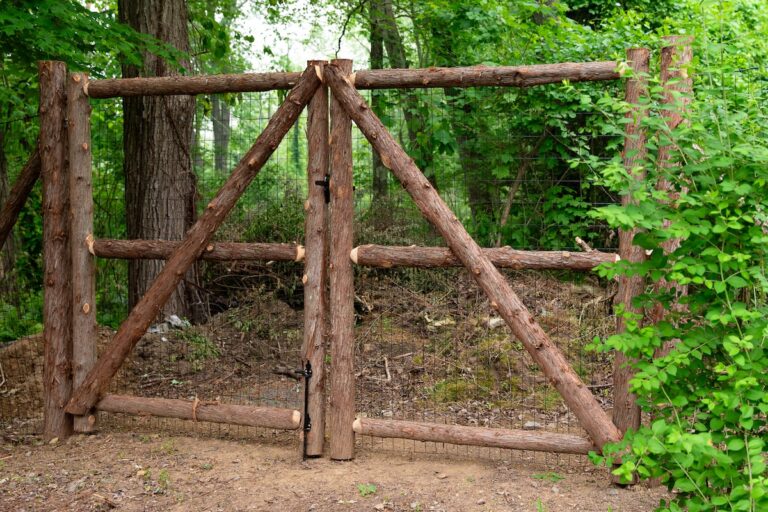 A tall wood fence gate made from live edge logs.