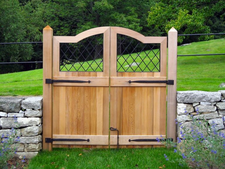 Wood walk gate with metal design and stone fencing