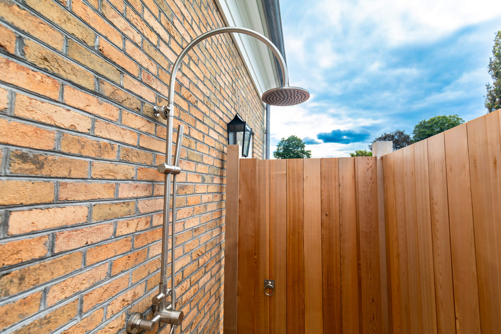 Outdoor shower enclosure against brick wall