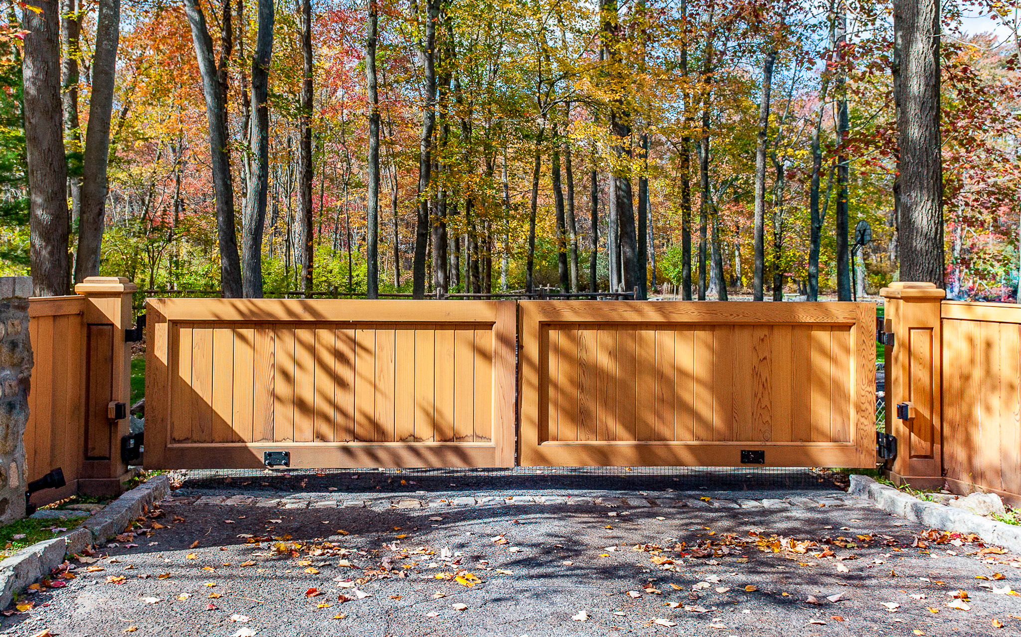 solid wood driveway gate in a forest entryway