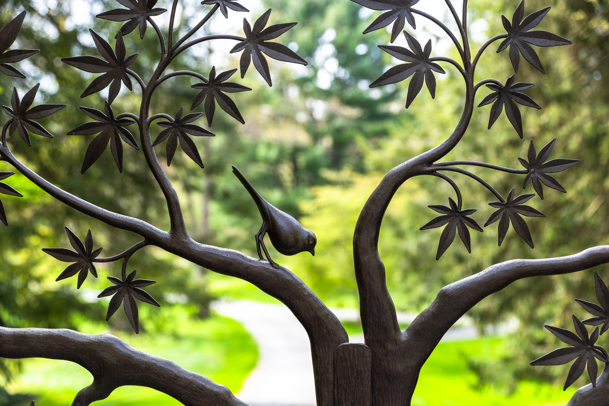 A closer look at the leaves and bird of the tree design in this driveway gate design