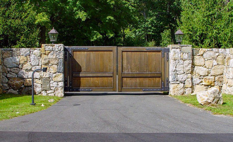 old world driveway gate with stonewalls and pillars