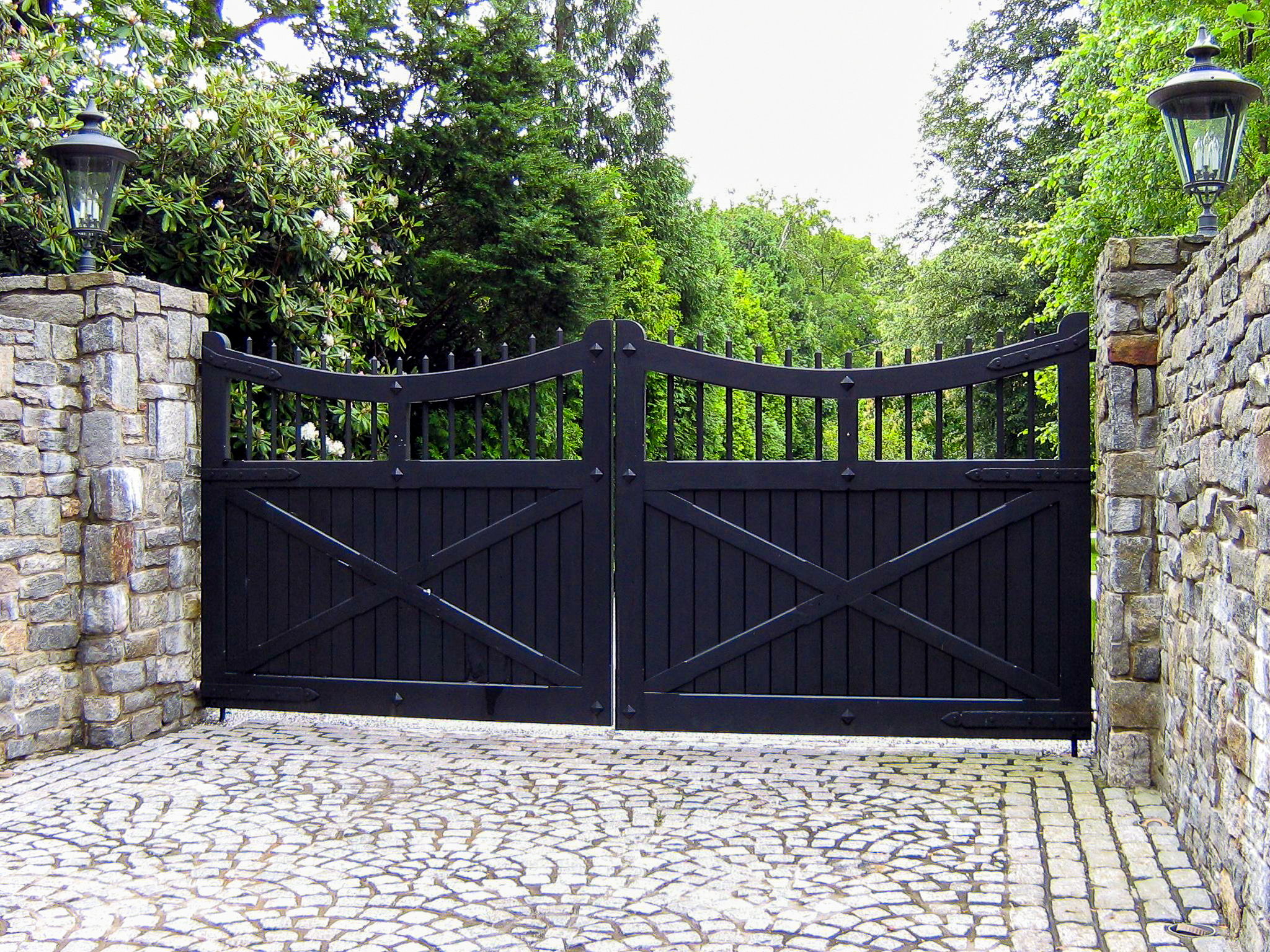 black fortress-like driveway gate in a castle-like estate