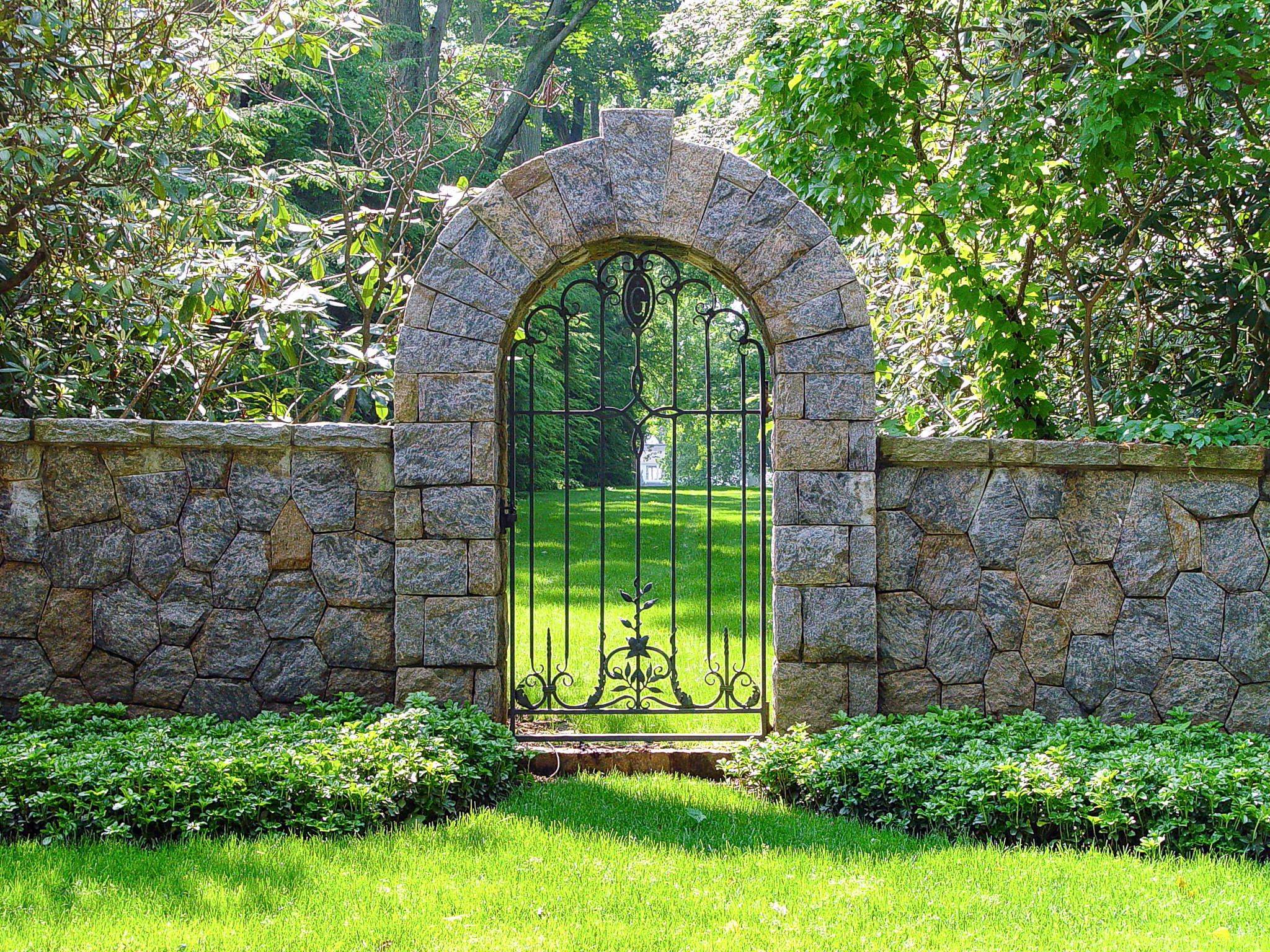 Stone arched walk gate made from wrought iron