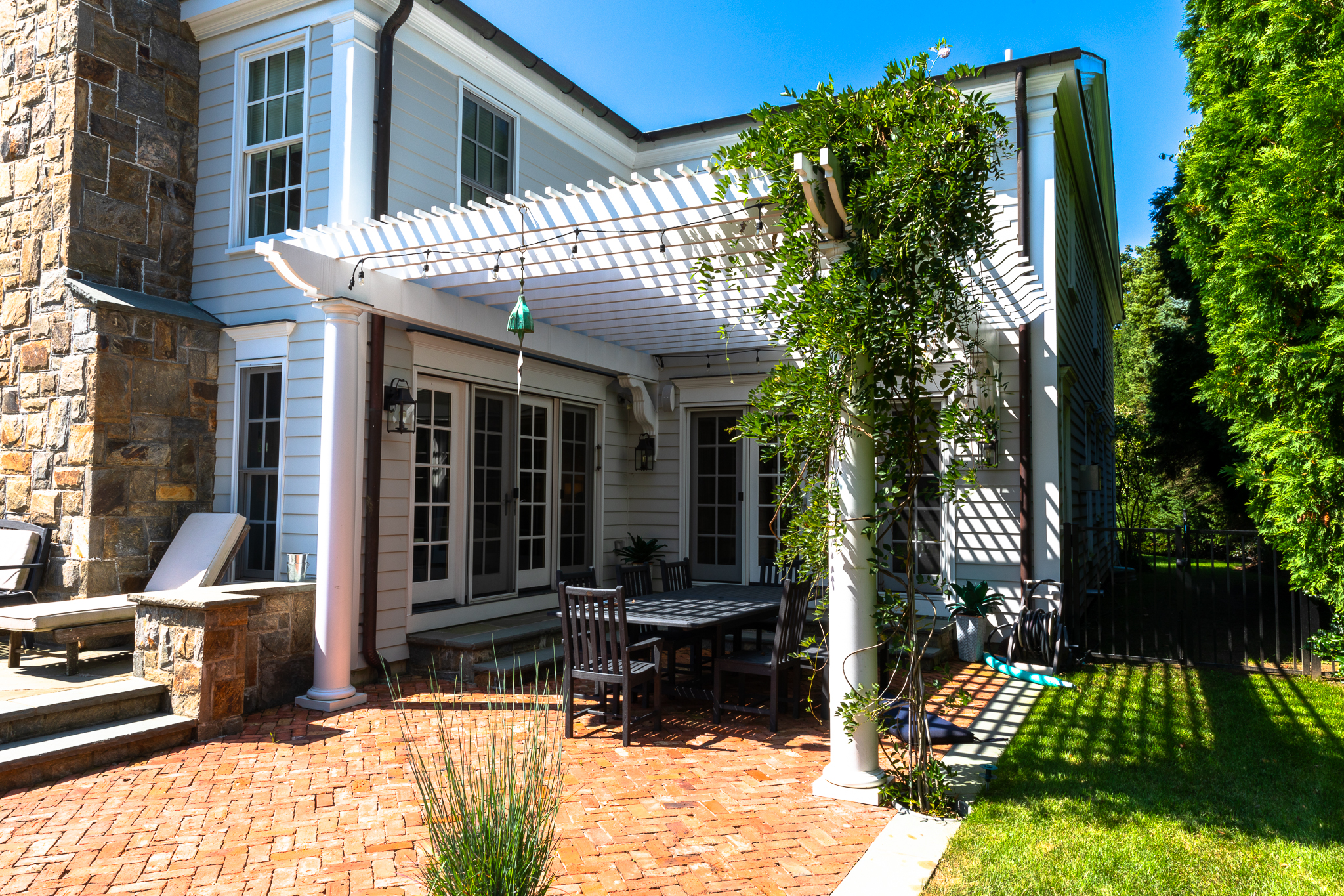 white pergola creates an extension of the home