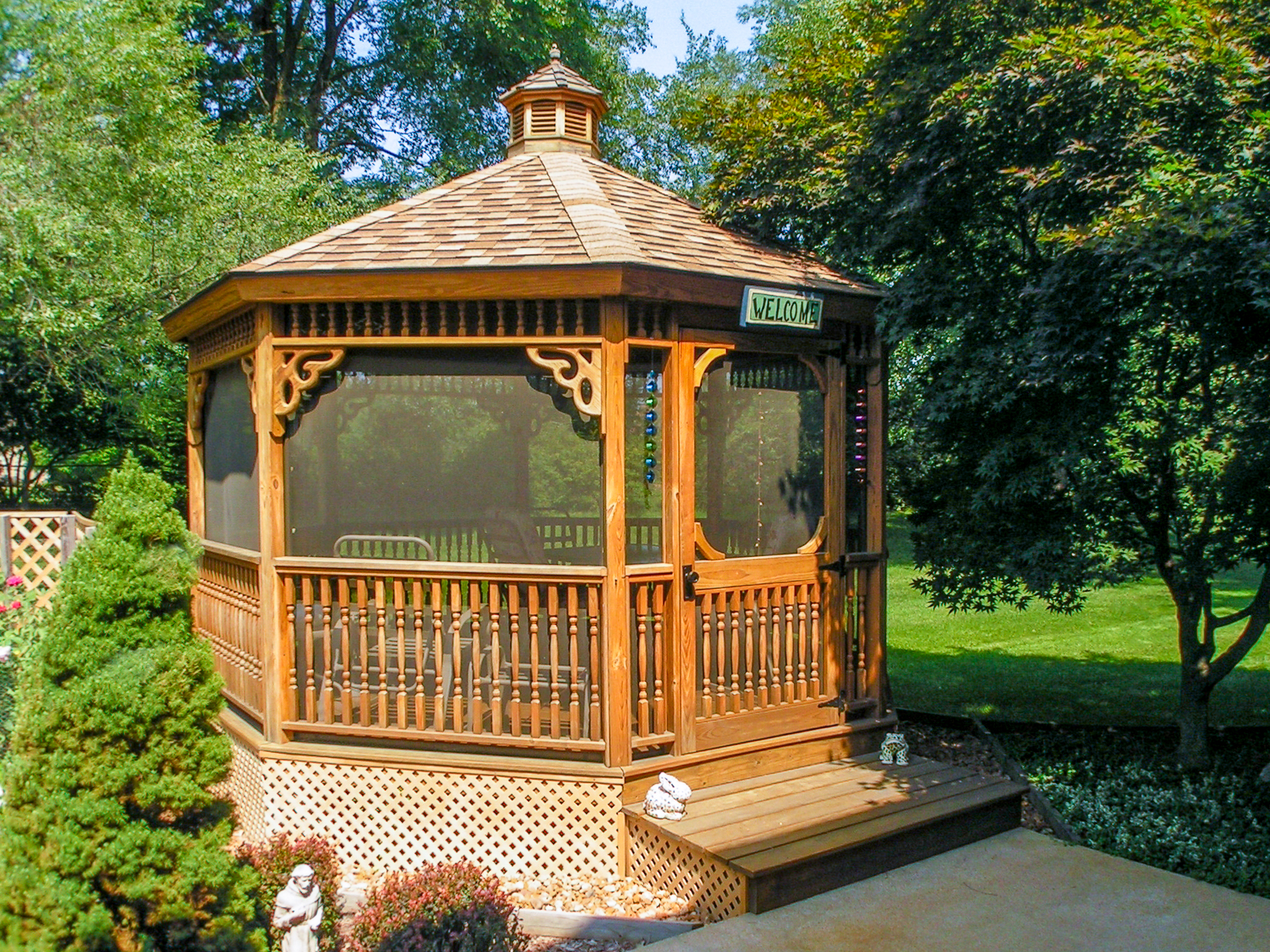 wood screened in gazebo with shingled roof