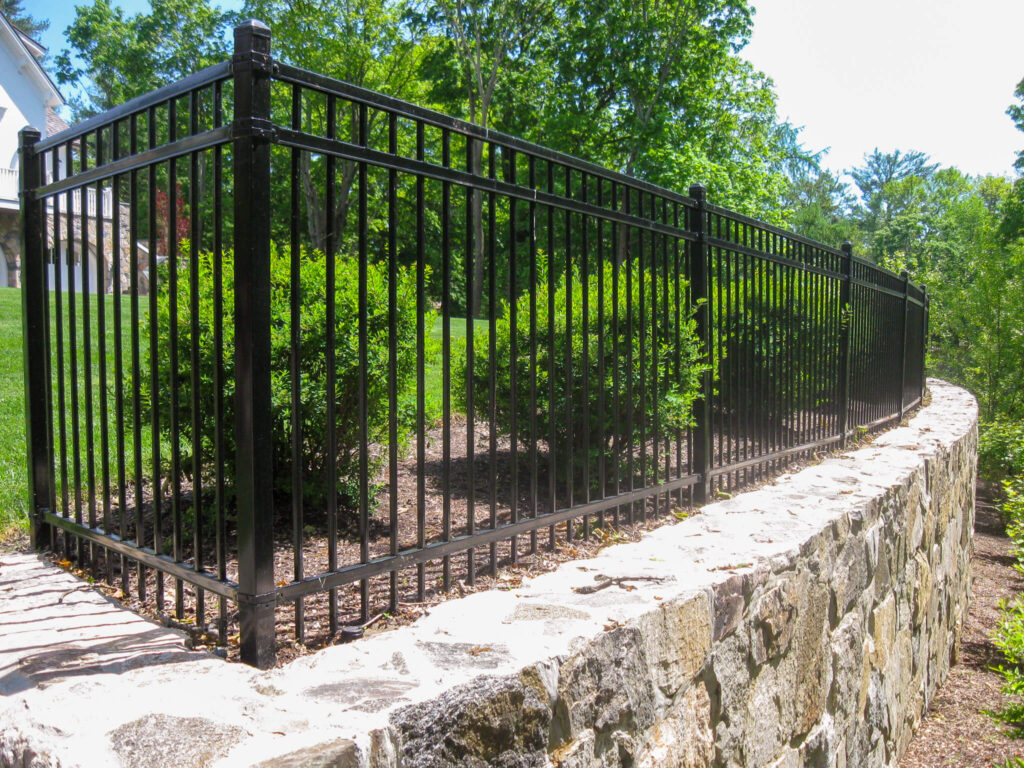 Black aluminum fence retaining wall installation