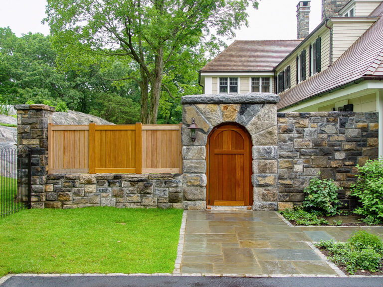 stone wall integrated cedar fence with arch doorway 