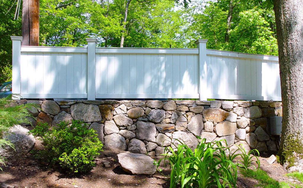 White fencing on a stone retaining wall