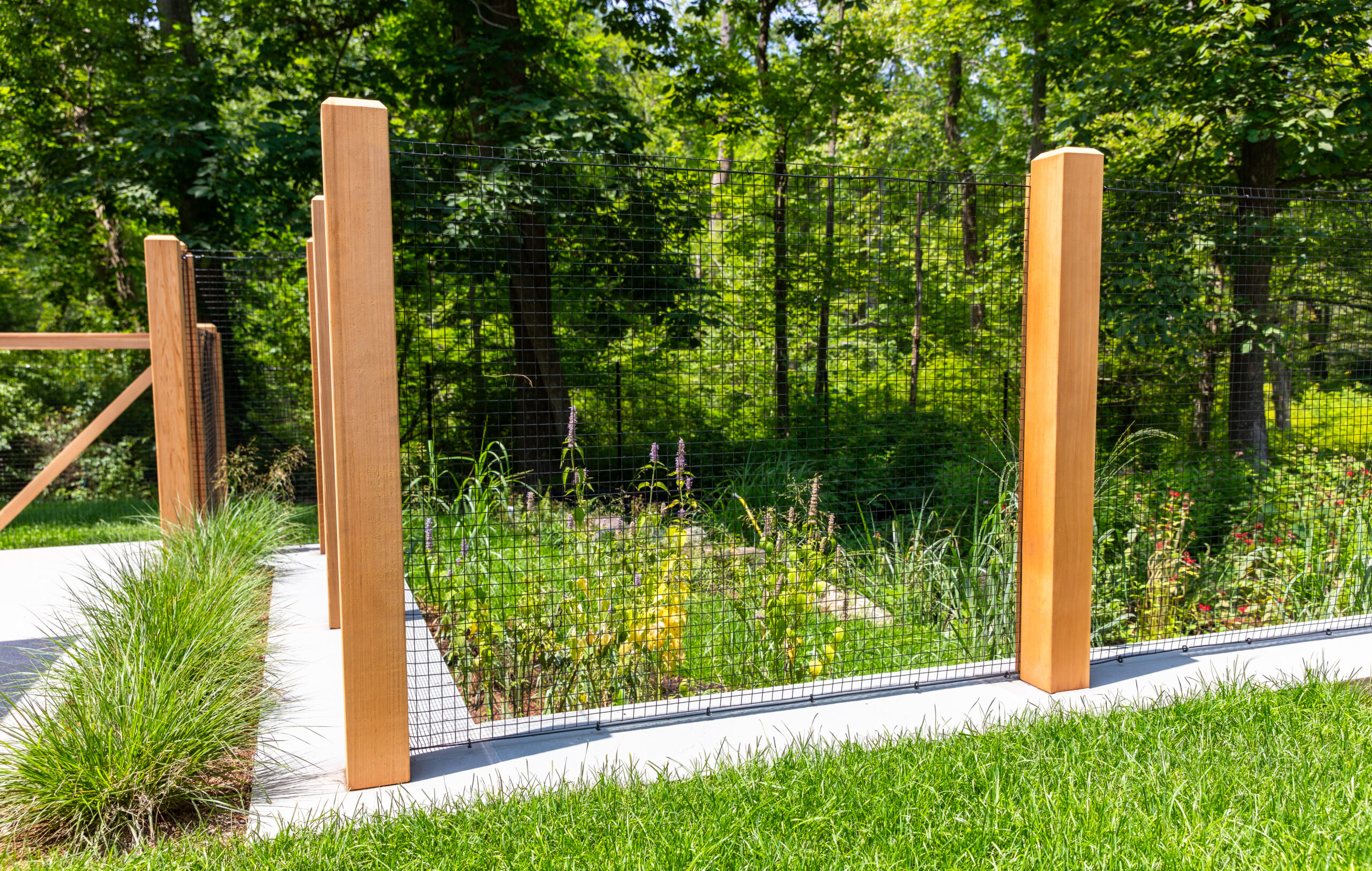 black mesh garden fence idea with wood posts