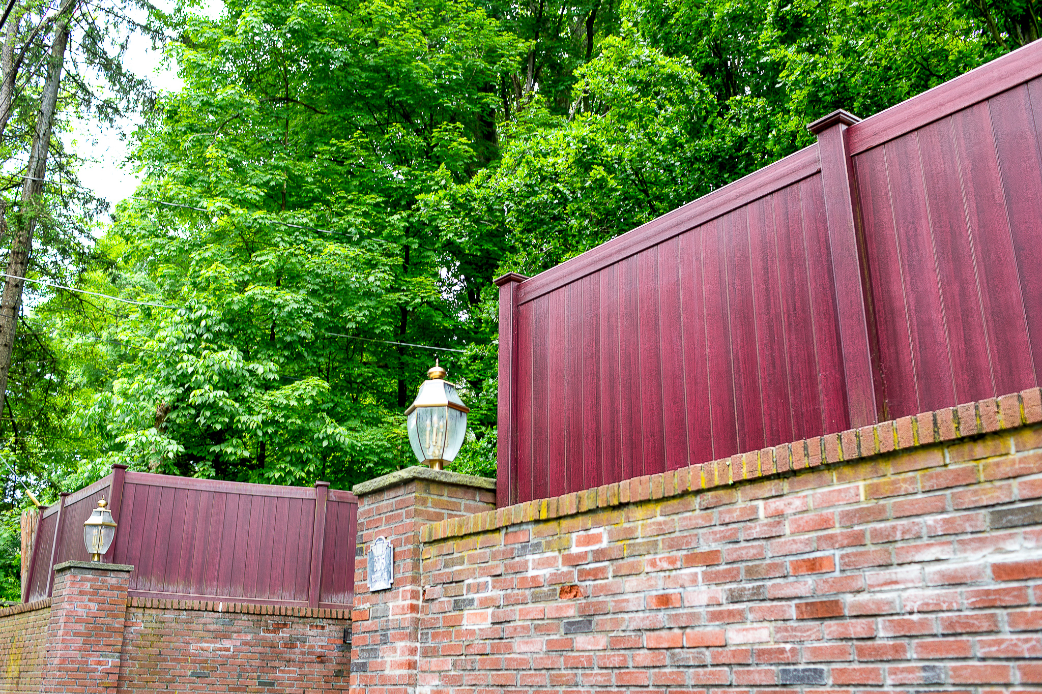 Beautiful red wood security fence installation on brick wall, also for privacy