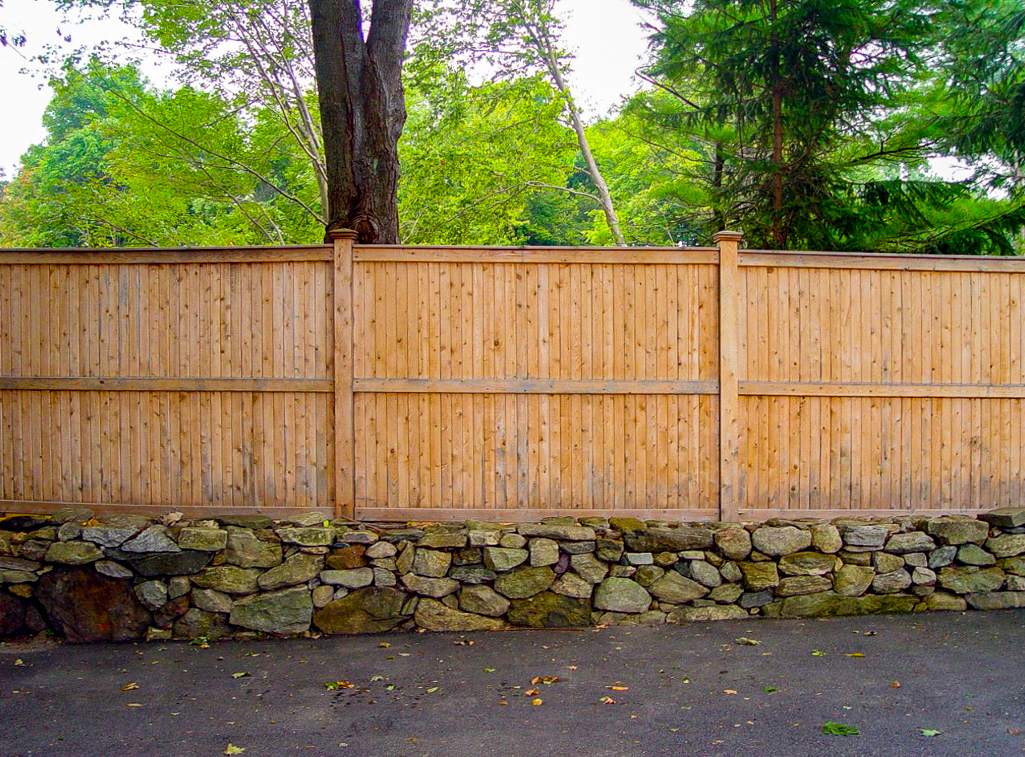 Tall Wood Security Fence Installed on a Stonewall